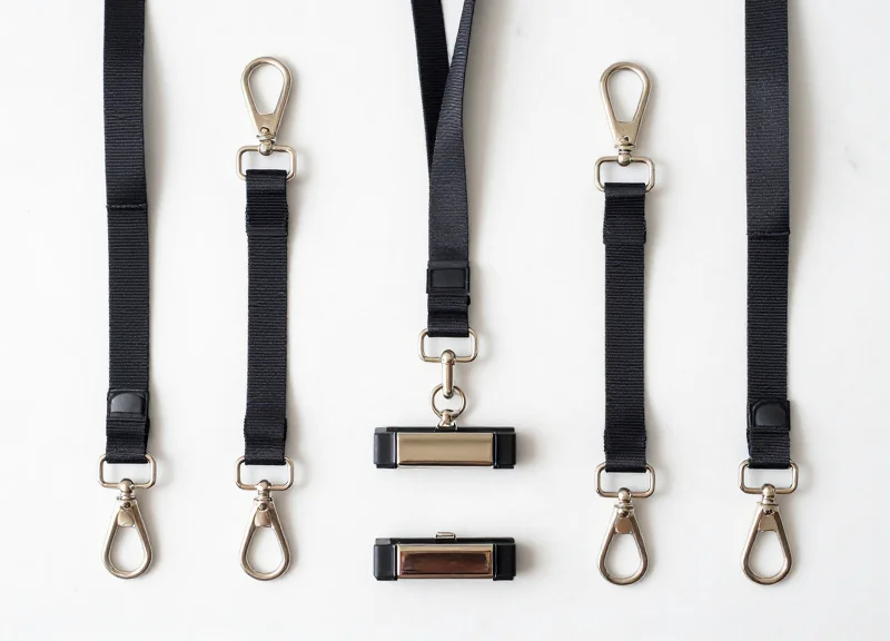 A collection of high-quality security lanyards and magnetic clamps for leather goods, neatly arranged.