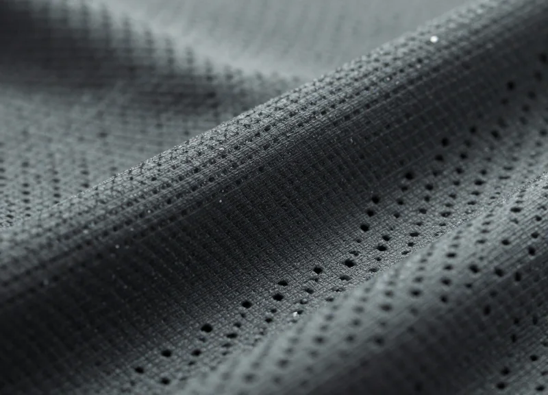 Detailed macro shot of high-tech moisture-wicking fabric showing complex textile weave and texture.