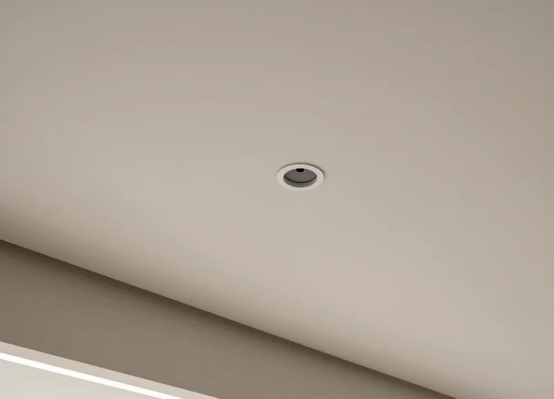 Minimalist high-end retail ceiling with a discreetly integrated circular security sensor.
