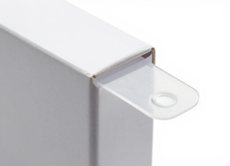 A clear, damage-free adhesive security tag applied to the corner of a high-quality product box.