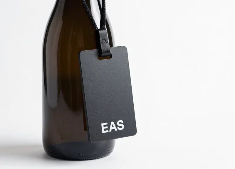 A premium bottle with a sleek EAS security tag around the neck on a clean background.