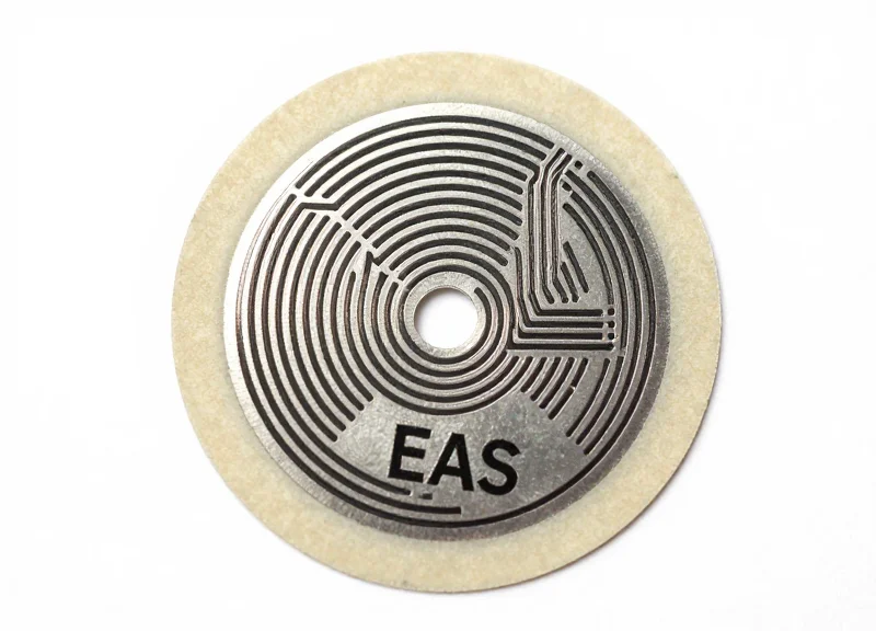 Detailed macro view of a high-bond EAS soft security tag showing its internal antenna circuit and adhesive backing.