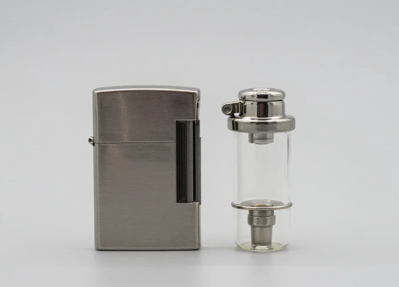 Macro photography of a sleek metal lighter and a glass atomizer on a clean background.