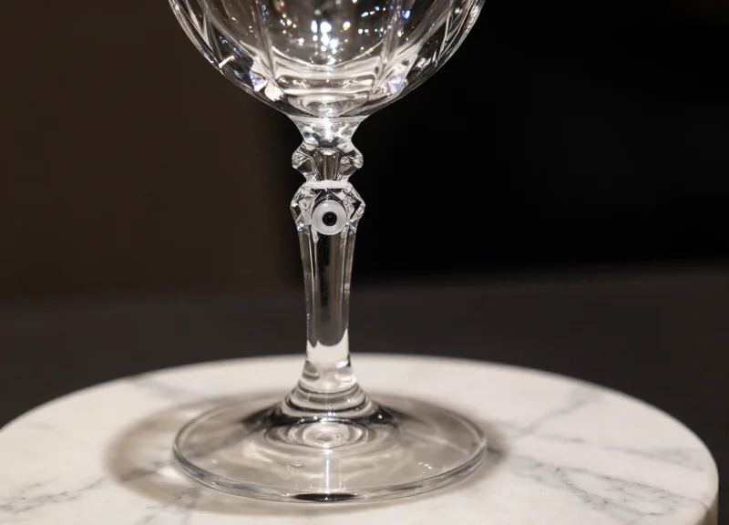 Close-up of a luxury crystal glass with a discreet, aesthetically integrated security tag.