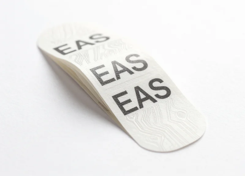 A close-up view of specialized EAS soft labels on a pure white background
