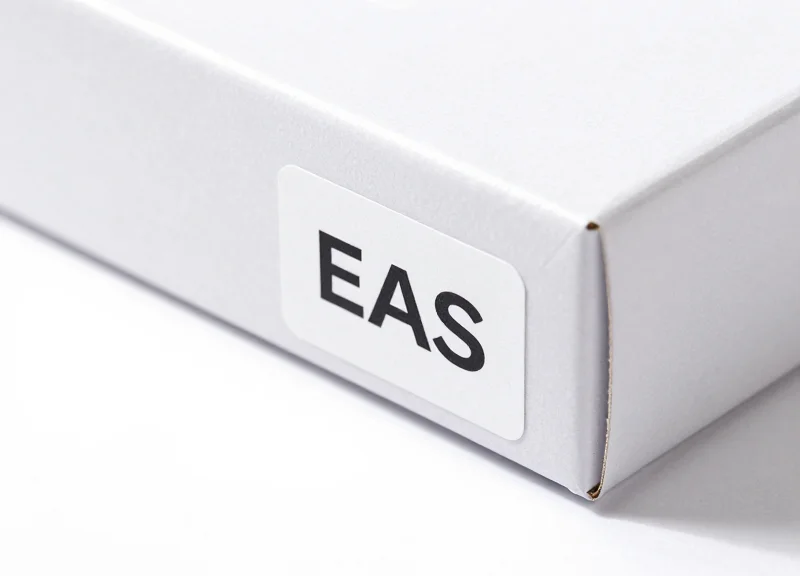 Macro shot of a high-tech EAS security label on a minimalist product box.