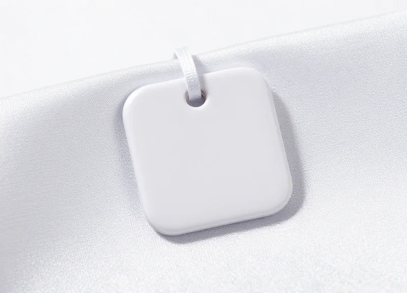 Macro shot of a high-end magnetic security tag attached to a delicate silk garment.