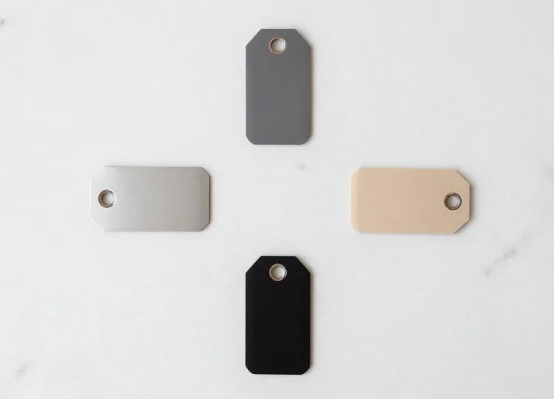 A collection of five different modern optical security tags arranged neatly on a marble surface