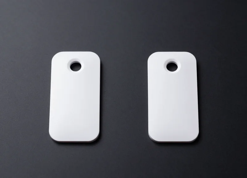 Two different models of high-tech security tags side-by-side on a professional studio surface.