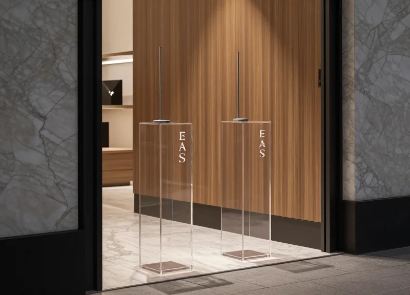Sleek, transparent glass EAS pedestals in a high-fashion showroom.