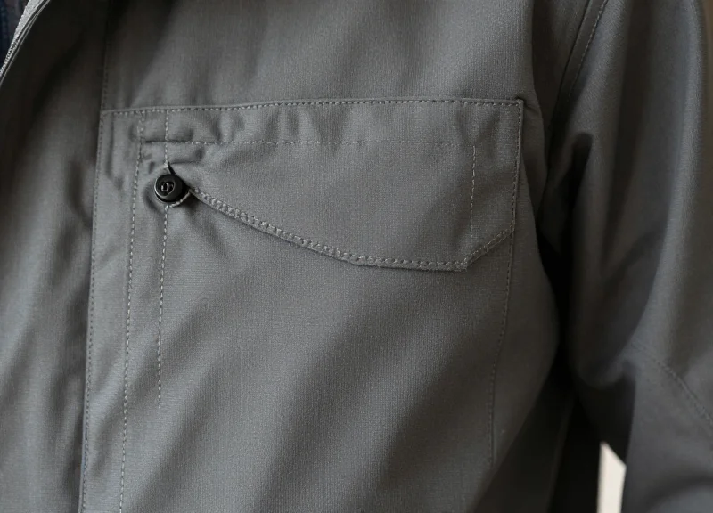 Close-up of a small fabric pocket on the interior lining of a technical jacket.