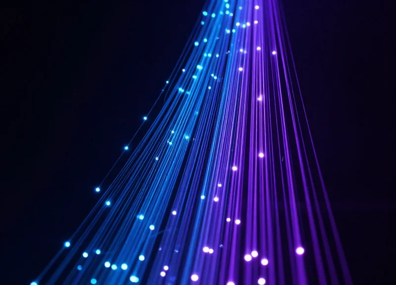 Abstract visualization of glowing data streams representing high-speed baggage information flow.