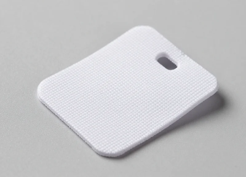Close-up of a durable industrial RFID tag for textile tracking on a clean background.