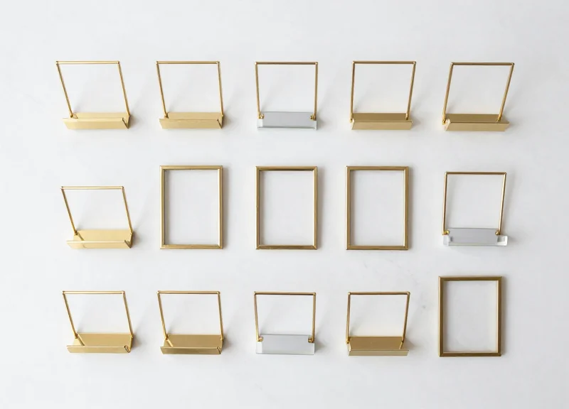 A collection of various mounting hardware and decorative frames for jewelry price tags.